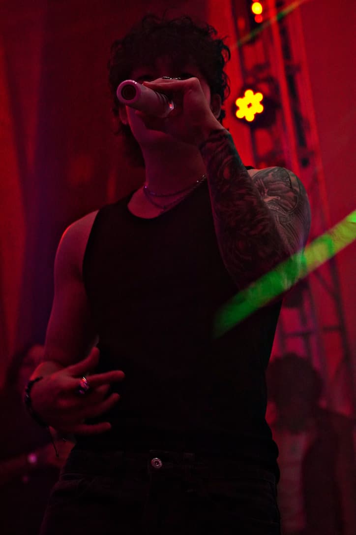 Sam Suen performing live on stage under red lights