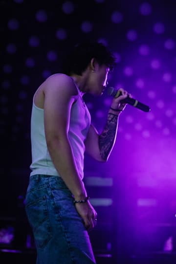 Sam Suen on stage with purple lighting
