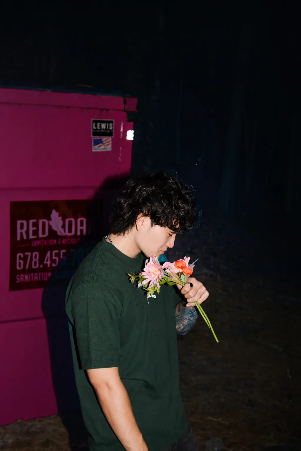 Sam Suen at night holding flowers